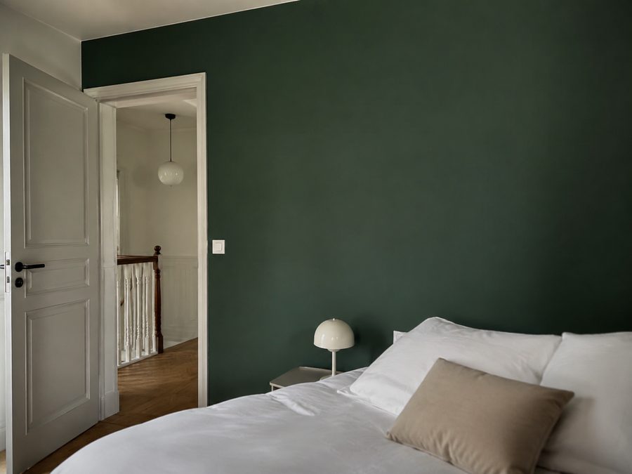 Chambre avec un mur vert foncé fraîchement peint (photo d'illustration)
